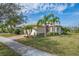 Charming single-story home featuring tropical landscaping, a tile roof and an attached two-car garage at 16127 Cape Coral Dr, Wimauma, FL 33598