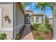 Inviting entrance with brick walkway, meticulously landscaped garden, and a charming screened doorway at 16127 Cape Coral Dr, Wimauma, FL 33598