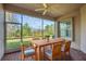 Relaxing screened patio with a wood dining table, ceiling fan, and brick-paved floor at 16127 Cape Coral Dr, Wimauma, FL 33598