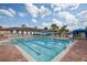 Large lap pool in community with blue and white lane lines next to deck with sun loungers and cabana at 16127 Cape Coral Dr, Wimauma, FL 33598