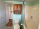 Clean bathroom with a toilet, tub, and overhead cabinet at 1710 7Th Sw St # 83, Ruskin, FL 33570