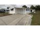 White mobile home with a driveway and mature trees in the background at 1710 7Th Sw St # 83, Ruskin, FL 33570