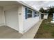 Side view of a white mobile home showcasing the garage and landscaping at 1710 7Th Sw St # 83, Ruskin, FL 33570