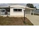 Front view of a white mobile home with a carport and small lawn at 1710 7Th Sw St # 83, Ruskin, FL 33570