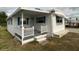 White mobile home with blue accents, covered porch, and landscaped yard at 1710 7Th Sw St # 83, Ruskin, FL 33570