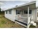 White single-wide home with covered porch and landscaping at 1710 7Th Sw St # 83, Ruskin, FL 33570