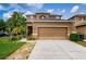 Two-story house with tan exterior, attached garage, and landscaped lawn at 17443 Glenapp Dr, Land O Lakes, FL 34638
