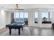 Living room with a pool table overlooking a beach view through large windows and a balcony door at 19734 Gulf Blvd # 202, Indian Shores, FL 33785