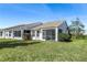 Home exterior showcasing a screened porch and well-maintained lawn at 20922 Jaffa Ln, Land O Lakes, FL 34637