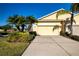 Front exterior showcasing a two-car garage and landscaping at 2501 Sapphire Greens Ln, Sun City Center, FL 33573