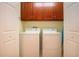 Bright laundry room, washer and dryer included, with wood cabinets at 2501 Sapphire Greens Ln, Sun City Center, FL 33573