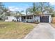 Ranch style home with a large front yard, palm trees and a driveway at 2755 Morningside Dr, Clearwater, FL 33759