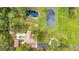 Aerial view showing home, pool, tennis court, and pond on a large property at 525 Appaloosa Rd, Tarpon Springs, FL 34688