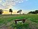 Wooden bench overlooking a serene waterfront park at sunset at 608 Florida Blvd, Crystal Beach, FL 34681