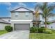 Two-story house with attached garage and landscaping at 6180 Apple Snail Ave, New Port Richey, FL 34653