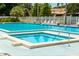 Sparkling community pool and spa with poolside lounge chairs for relaxing on a sunny day at 6210 92Nd N Pl # 3405, Pinellas Park, FL 33782