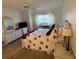 Main bedroom with a king-size bed, wicker furniture, and wood floors at 7050 Sunset S Dr # 208, South Pasadena, FL 33707
