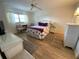 Spacious bedroom with a queen bed, wicker furniture, and wood floors at 7050 Sunset S Dr # 208, South Pasadena, FL 33707