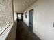 A well-lit hallway with tiled floors and access to condo units at 7050 Sunset S Dr # 208, South Pasadena, FL 33707