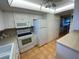 White kitchen features an electric range, microwave, and refrigerator at 7050 Sunset S Dr # 208, South Pasadena, FL 33707