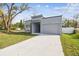 Modern home with gray exterior, stone accents, and attached garage at 7711 N Orleans Ave, Tampa, FL 33604