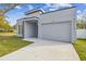 Newly built home with gray exterior, stone accents, and attached garage at 7711 N Orleans Ave, Tampa, FL 33604