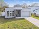 Modern house with gray exterior, attached garage, and a stone accent wall at 7711 N Orleans Ave, Tampa, FL 33604