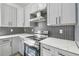 Modern kitchen with gray cabinets, quartz countertops, and herringbone backsplash at 7711 N Orleans Ave, Tampa, FL 33604