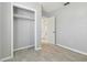 Neutral bedroom with a closet, light wood-look floors, and a doorway to another room at 9415 Forest Hills Dr, Tampa, FL 33612