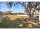 Spacious backyard with mature oak tree and wooden fence at 9422 Bellhaven St, Temple Terrace, FL 33637