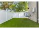 Artificial turf backyard with AC unit and fence at 108 E Chelsea St, Tampa, FL 33603