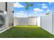 Artificial turf backyard with AC unit and gate at 108 E Chelsea St, Tampa, FL 33603