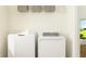 Bright laundry room with washer, dryer, and shelving at 10816 Fort White Ct, Tampa, FL 33647