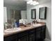 Double vanity bathroom with dark cabinets and a large mirror at 11036 Paradise Point Way, New Port Richey, FL 34654