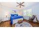 Main bedroom with king-size bed, ceiling fan, and hardwood floors at 11036 Paradise Point Way, New Port Richey, FL 34654