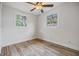 Bright bedroom with ceiling fan, two windows, and light brown laminate flooring at 11882 104Th St, Largo, FL 33773