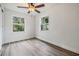 Well-lit bedroom with ceiling fan, two windows, and light brown laminate flooring at 11882 104Th St, Largo, FL 33773