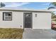 House exterior showcasing a dark gray door and white stucco siding at 11882 104Th St, Largo, FL 33773