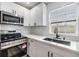 Modern kitchen with white cabinets, stainless steel appliances, and a black farmhouse sink at 11882 104Th St, Largo, FL 33773