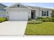 Two-car garage and well-maintained front yard at 12772 Achasta Blvd, Hudson, FL 34669