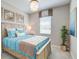 Bedroom with light wood bed frame, teal bedding, and coastal artwork at 14960 Serene Shores Loop, Bradenton, FL 34211