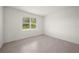 Simple bedroom with grey carpet, large window, and neutral walls at 15143 Sea Salt Way, Bradenton, FL 34211