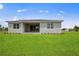 Rear view of single-story house with covered patio and grassy yard at 15143 Sea Salt Way, Bradenton, FL 34211