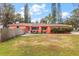 Bright coral house with a lush green lawn and manicured hedges at 1530 Rollen Rd, Clearwater, FL 33755