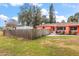 Charming coral house with a well-manicured lawn and wooden fence at 1530 Rollen Rd, Clearwater, FL 33755