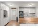 White kitchen with butcher block island and stainless appliances at 1530 Rollen Rd, Clearwater, FL 33755