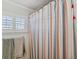 Shower stall with striped shower curtain and window with shutters at 15707 Crystal Waters Dr, Wimauma, FL 33598