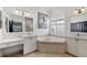 Elegant bathroom with double vanity, corner bathtub, and large mirror at 15707 Crystal Waters Dr, Wimauma, FL 33598