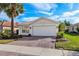 One-story house with a white garage door and lush landscaping at 15707 Crystal Waters Dr, Wimauma, FL 33598