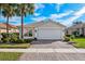 House exterior with a paved driveway and lush landscaping at 15707 Crystal Waters Dr, Wimauma, FL 33598